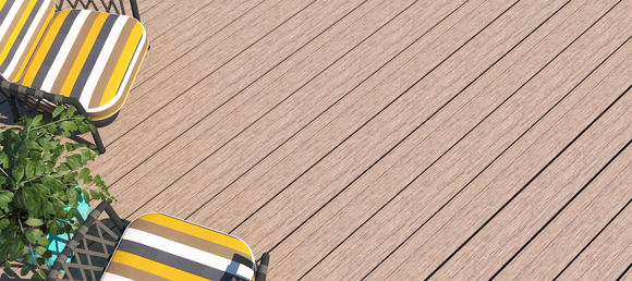 Striped chairs with yellow, black, and white cushions sit on a light wooden deck, with green foliage providing a touch of nature. Bright and inviting.