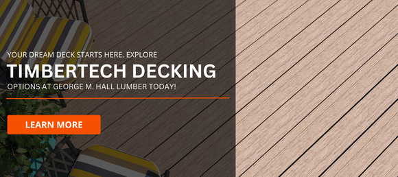 Modern composite decking with a sleek woodgrain finish, partially shaded by outdoor furniture with striped cushions. Promotional banner text reads: 'Your dream deck starts here. Explore TimberTech Decking options at George M. Hall Lumber today!' A bright orange 'Learn More' button is included.